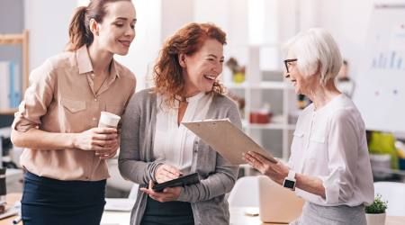 Drei Frauen aus verschiedenen Generationen freuen sich gemeinsam bei der Arbeit